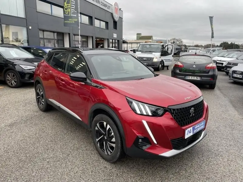 Peugeot 2008 130 GT-LINE rouge métal vue 3/4 avant droit, avec toit noir et signature lumineuse verticale LED.