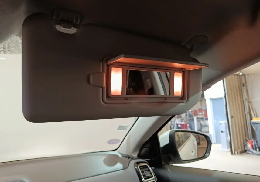 Miroir de courtoisie éclairé sur pare-soleil côté conducteur dans l’habitacle d’un Citroën C5 Aircross blanc.