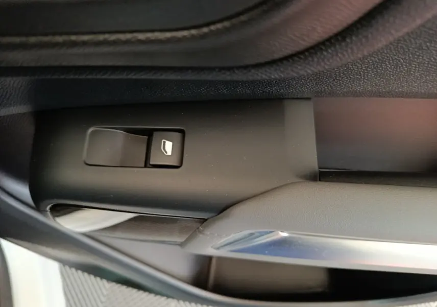 Bouton de commande de vitre sur la portière intérieure côté conducteur du Citroën C5 Aircross blanc, vue rapprochée.