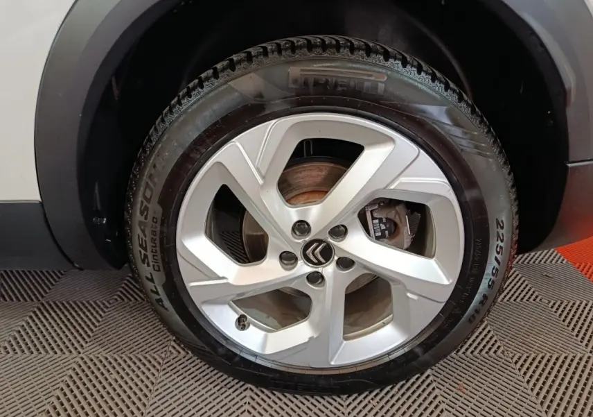 Gros plan sur la roue avant droite blanche d’un Citroën C5 Aircross Hybrid avec jante alliage et pneu Pirelli.
