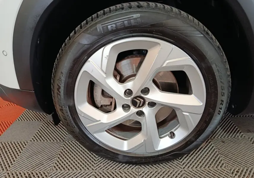 Gros plan sur la roue avant gauche du Citroën C5 Aircross blanc, avec jante alliage et pneu Pirelli visible.