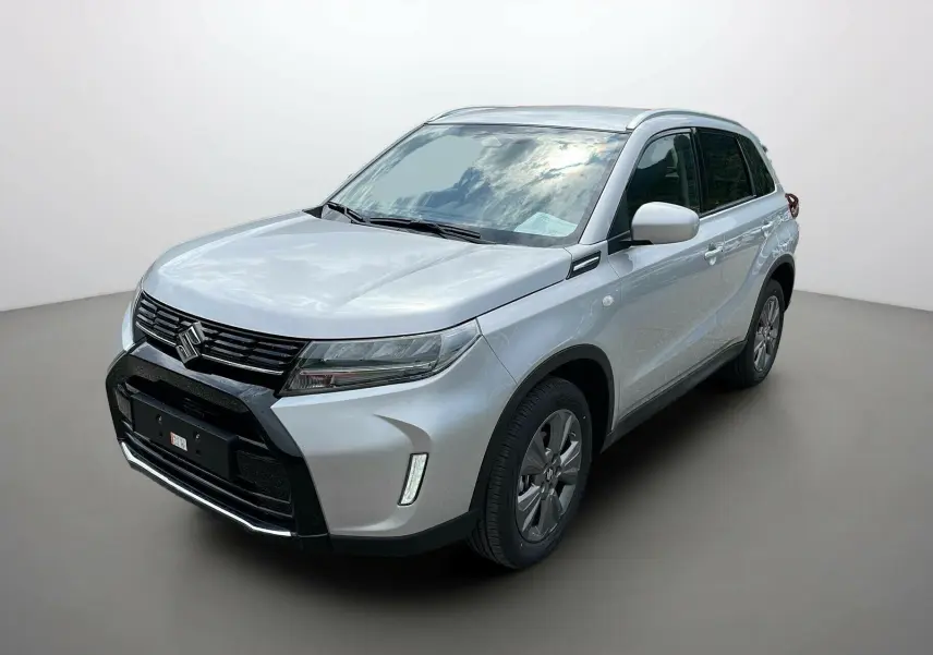 Suzuki Vitara 2025 gris argenté en 3/4 avant droit, avec calandre noire et feux LED distinctifs.