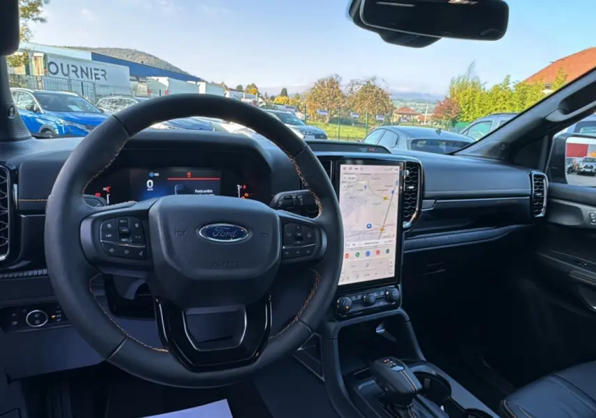 Vue intérieure du tableau de bord et volant cuir noir du Ford Ranger 2.3 PHEV Wildtrak Plus avec écran tactile vertical.