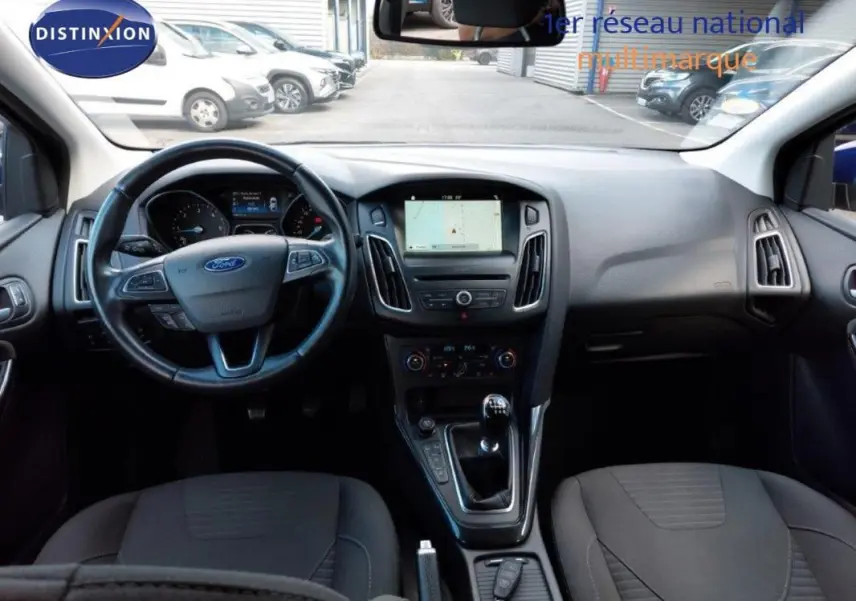 Vue intérieure avant de la Ford Focus SW 2018, tableau de bord noir avec écran tactile et volant multifonction.