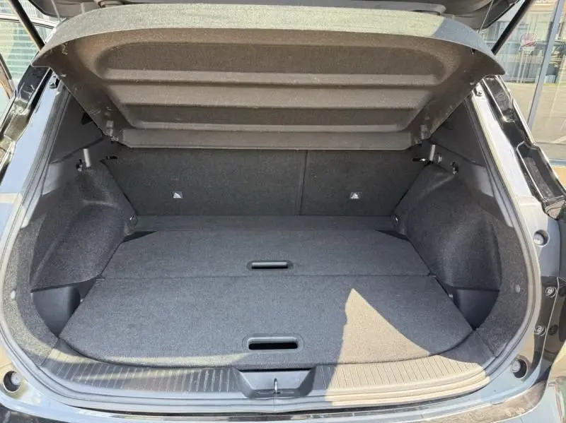 Coffre ouvert vu de l'arrière du Nissan Qashqai noir 2023, montrant un espace de chargement plat et spacieux.