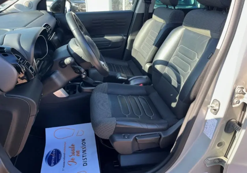 Vue intérieure côté conducteur du Citroën C3 Aircross 2019, sièges cuir/tissu noirs avec tableau de bord moderne.