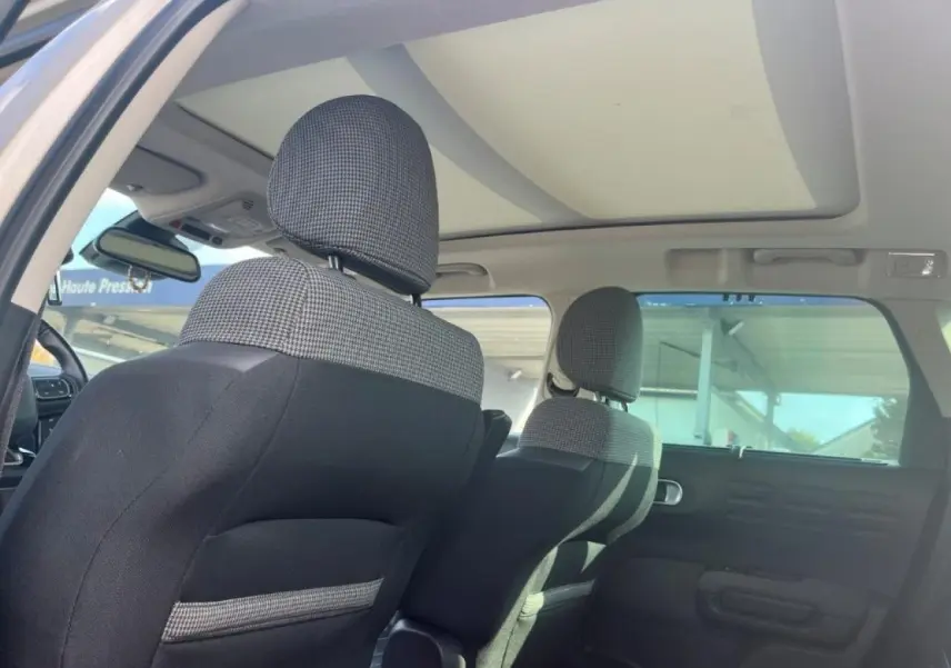 Vue intérieure arrière du Citroën C3 Aircross 2019 avec sièges tissu noir et gris et toit ouvrant panoramique en verre.