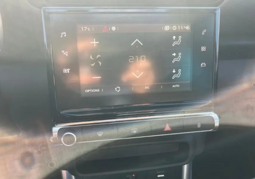 Écran tactile central du tableau de bord du Citroën C3 Aircross beige, affichant la climatisation à 21°C.