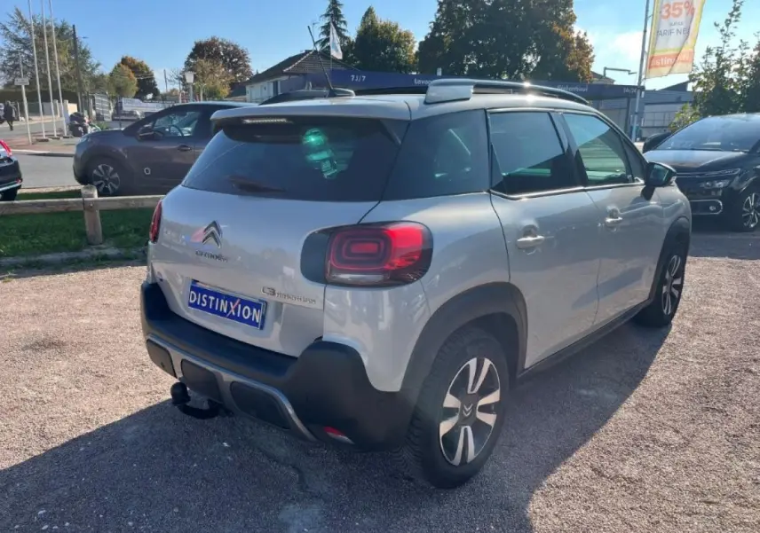 Vue 3/4 arrière droite d'un Citroën C3 Aircross beige avec attelage col de cygne et toit ouvrant panoramique.