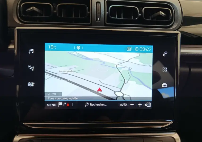 Écran tactile de navigation 7 pouces dans le tableau de bord noir d'une Citroën C3 blanche, vue intérieure rapprochée.