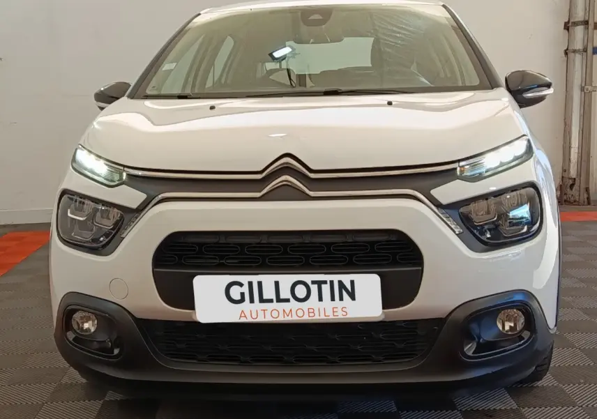 Vue frontale d'une Citroën C3 blanche 2020 avec feux LED allumés et calandre noire distinctive.