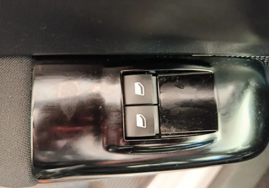 Gros plan sur les commandes des vitres électriques côté conducteur d'une Citroën C3 blanche, version 2020.