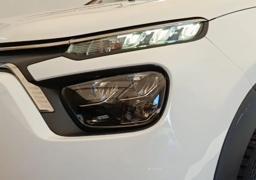 Gros plan sur le phare avant droit blanc de la Citroën C3 2020 avec éclairage LED distinctif et signature lumineuse.