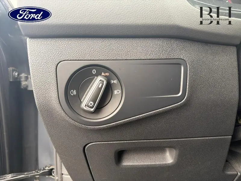 Sélecteur de phares noir sur tableau de bord gris texturé d’un Volkswagen Tiguan 2021, côté gauche.