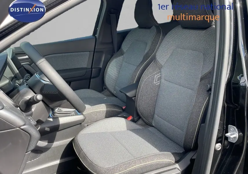 Vue intérieure côté conducteur du Renault Captur 2025, sièges tissu gris avec surpiqûres contrastantes et volant noir.