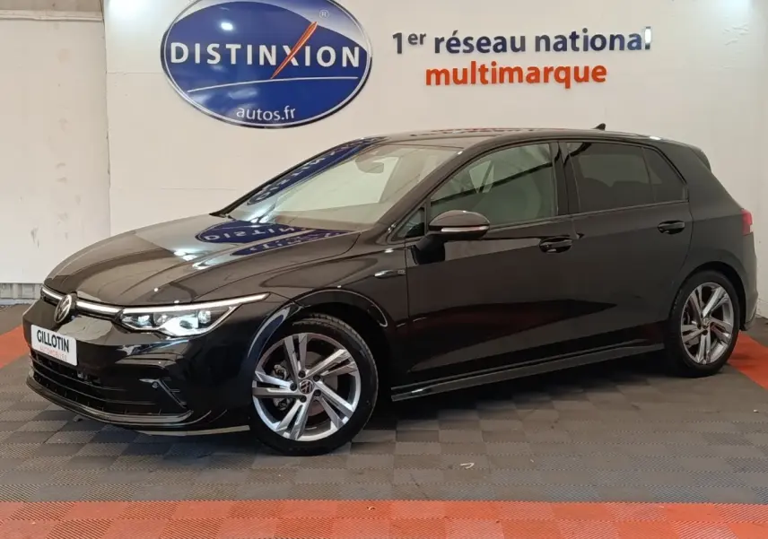 Volkswagen Golf 1.5 eTSI R-Line noire vue de profil droit en intérieur avec jantes alliage et phares allumés.