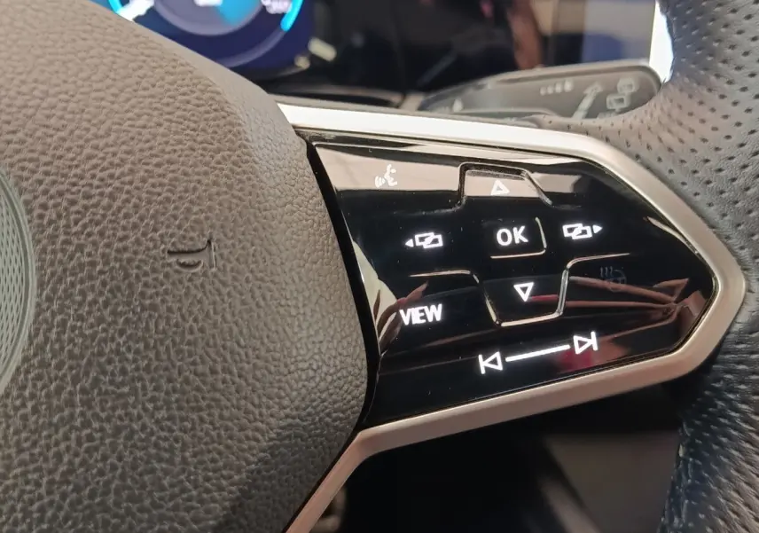 Gros plan sur les commandes noires et argentées du volant de la Volkswagen Golf 1.5 eTSI R-Line, côté droit.