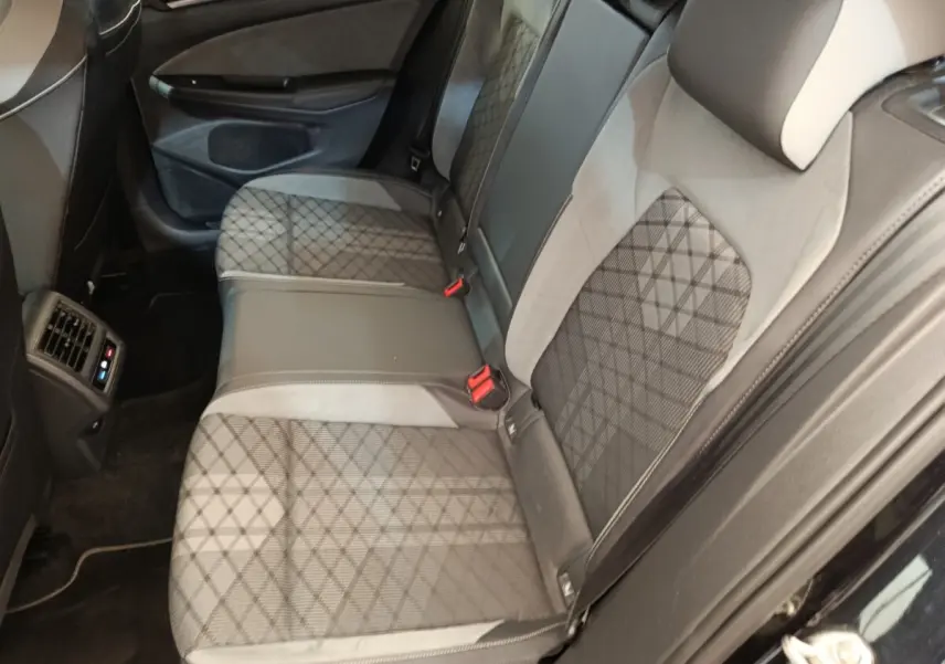 Vue intérieure côté arrière droit de la banquette arrière noire et grise avec motif quadrillé de la Volkswagen Golf 1.5 eTSI R-Line.