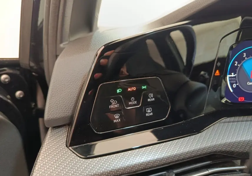 Détail du tableau de bord noir de la Volkswagen Golf 1.5 eTSI 2021 avec commandes d'éclairage et affichage digital partiel.