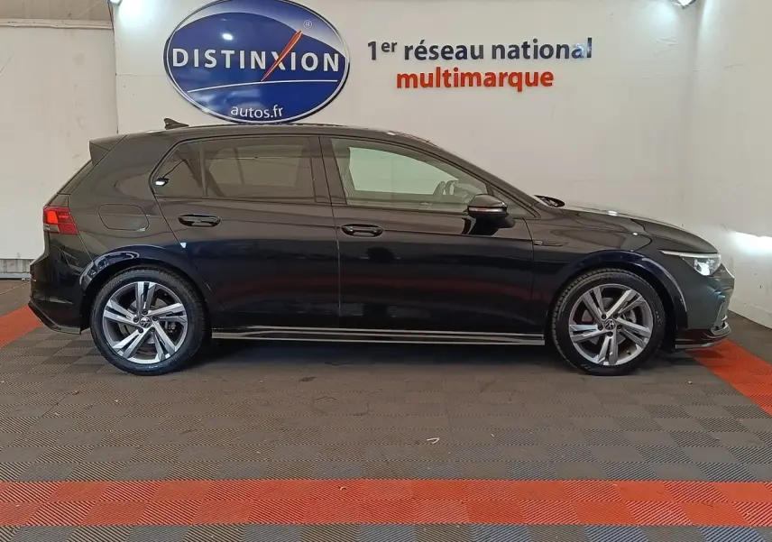 Volkswagen Golf 1.5 eTSI R-Line noire vue de profil côté gauche dans un showroom intérieur.