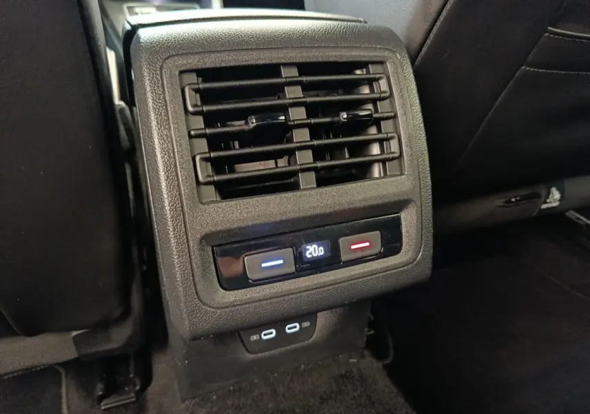 Détail de la console arrière noire de la Volkswagen Golf 1.5 eTSI R-Line avec commandes climatisation et ports USB.