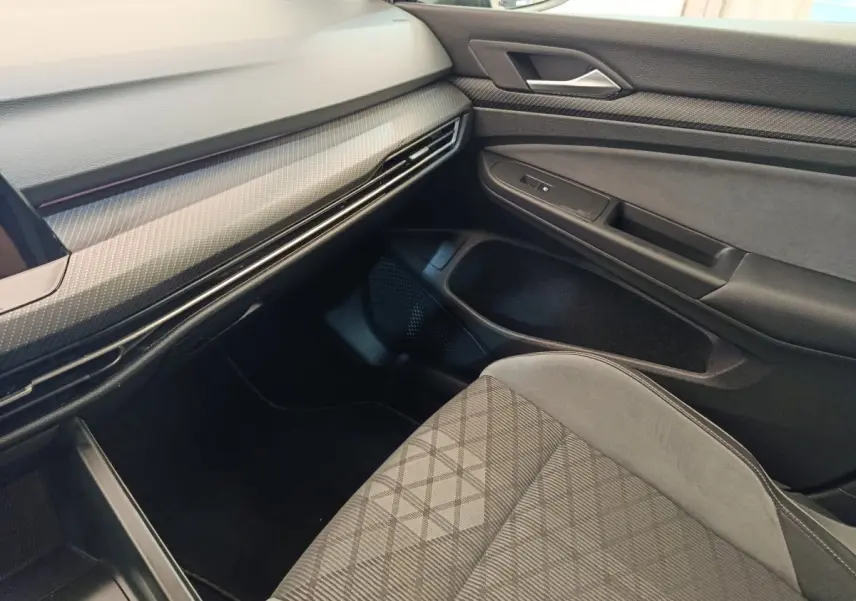 Vue intérieure côté passager de la Volkswagen Golf 1.5 eTSI R-Line 2021, avec siège tissu gris et tableau de bord noir.