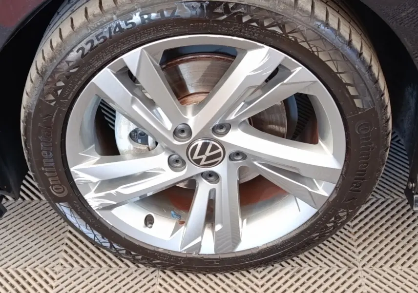 Gros plan sur la jante alliage argentée avec logo Volkswagen au centre d’une Golf noire 1.5 eTSI R-Line.