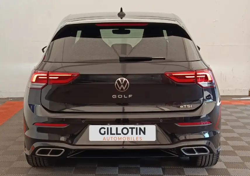 Vue arrière d'une Volkswagen Golf noire 1.5 eTSI avec feux LED et double sortie d'échappement rectangulaire.