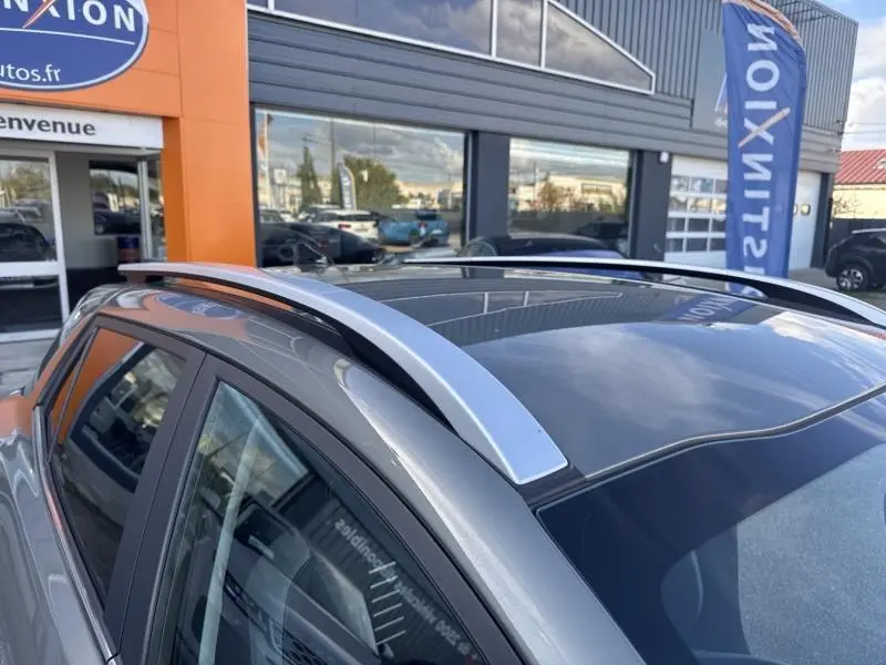 Détail des barres de toit argentées et toit panoramique sur le côté gauche d'un KIA Stonic brun Sienne 2019.