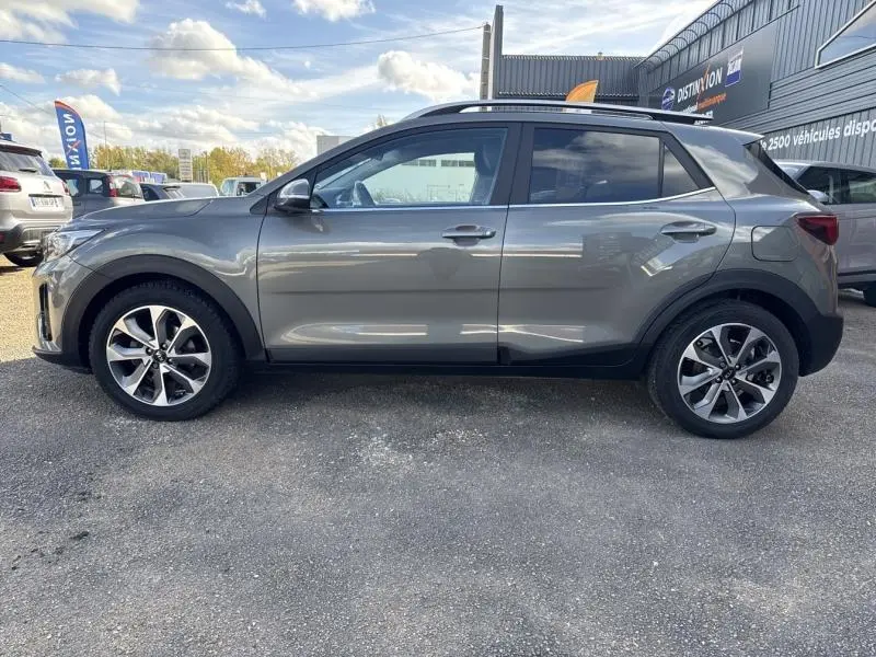 Vue latérale droite d'un Kia Stonic brun Sienne 2019 avec jantes alliage et vitres surteintées, stationné en extérieur.