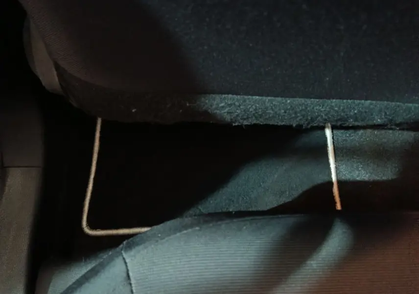 Vue rapprochée du tapis de sol noir sous le siège arrière d'une Toyota Corolla hybride blanche de 2022.