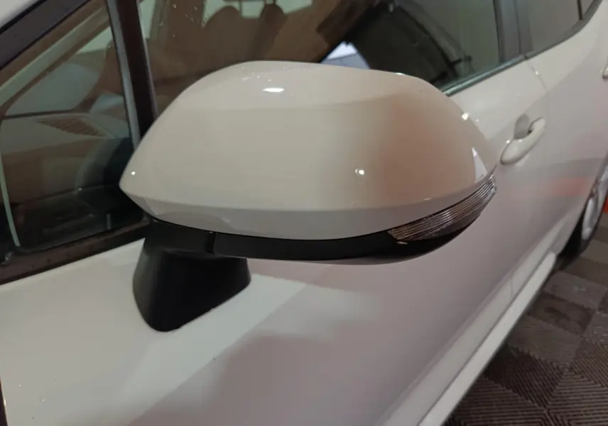 Rétroviseur électrique blanc côté gauche de la Toyota Corolla hybride 2022, avec clignotant intégré visible.