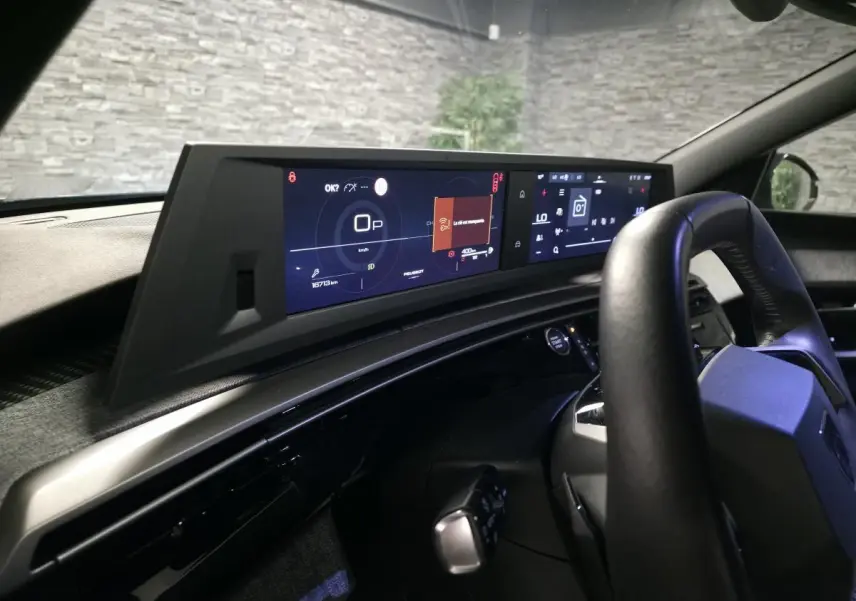 Vue intérieure du tableau de bord et volant noir de la Peugeot 5008 2025 avec double écran HD panoramique.