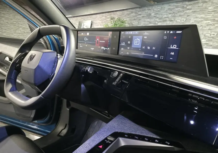 Vue intérieure côté conducteur du Peugeot 5008 bleu 2025, avec i-Cockpit panoramique et double écran HD flottant.