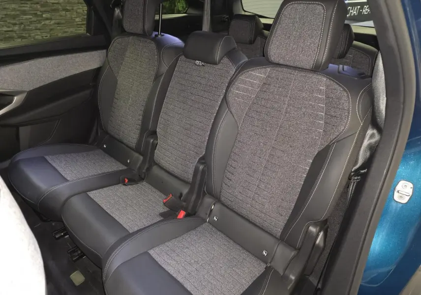Vue intérieure côté droit des sièges arrière en tissu gris et cuir noir du Peugeot 5008 bleu 2025.