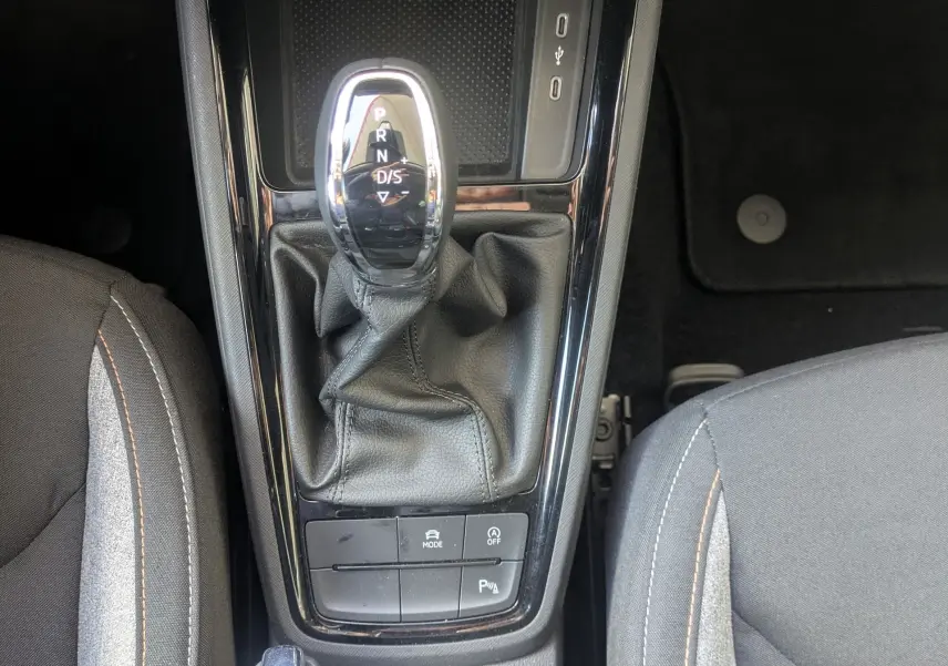 Vue plongeante sur la console centrale de la Skoda Scala gris reflex, avec levier de vitesse automatique et commandes climatisation.