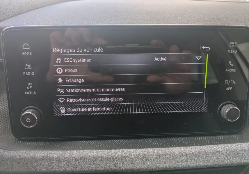 Écran tactile central de la Skoda Scala gris Reflex affichant les réglages du véhicule en mode menu.