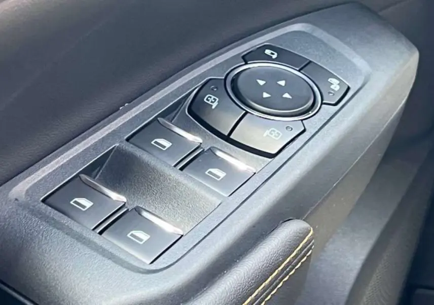 Gros plan sur les commandes des vitres électriques et rétroviseurs côté conducteur du Ford Ranger Wildtrak Plus 2025.
