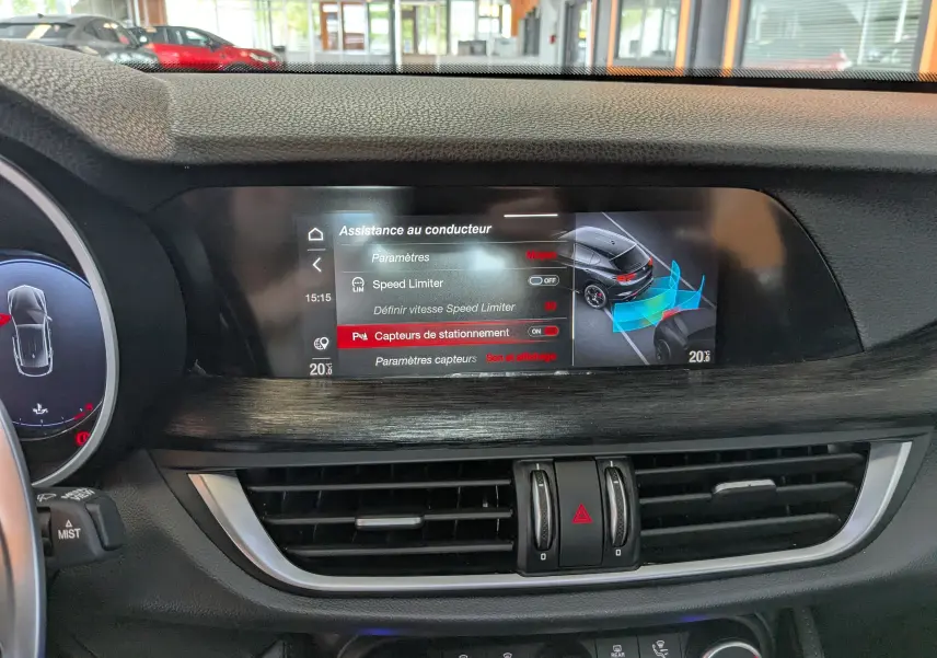 Écran central tactile de l'Alfa Romeo Stelvio noir 2023 montrant l'assistance au conducteur et capteurs de stationnement.
