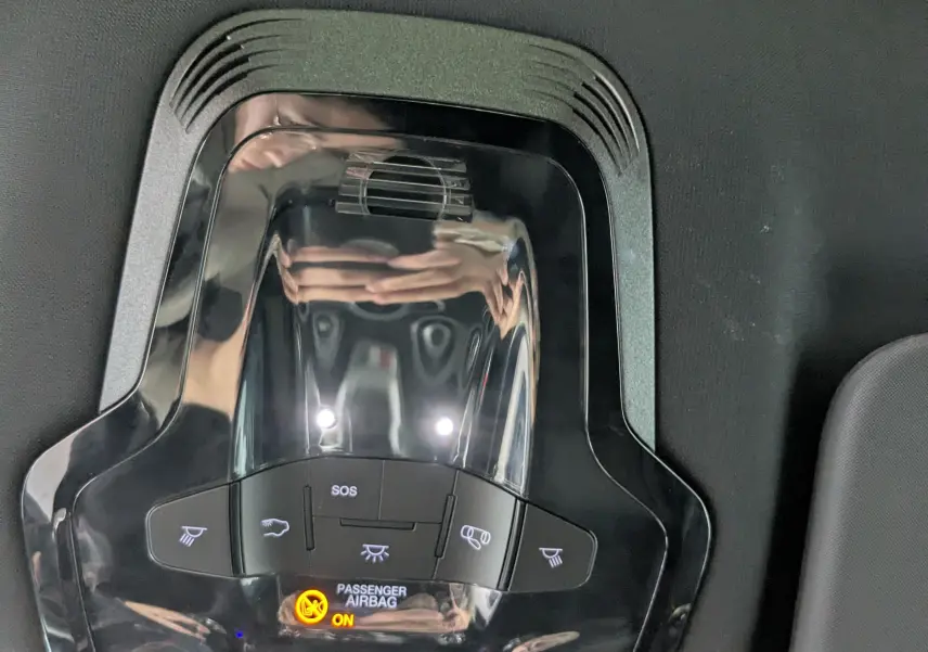 Panneau de commandes de toit noir brillant avec éclairage intérieur et indicateur airbag passager activé dans un Alfa Romeo Stelvio noir.