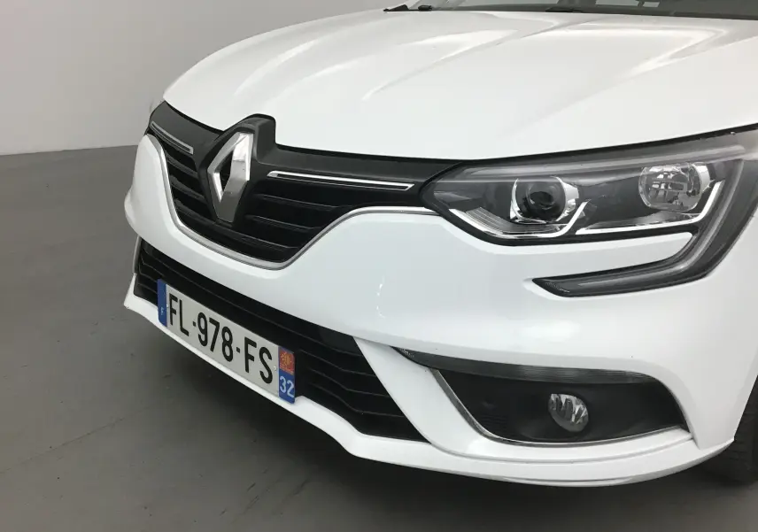 Vue avant droite d'une Renault Mégane IV Berline blanche de 2019 avec phares LED et calandre noire distinctive.