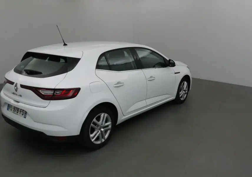 Renault Mégane IV berline blanche vue de 3/4 arrière droit dans un studio gris, avec feux arrière allumés.