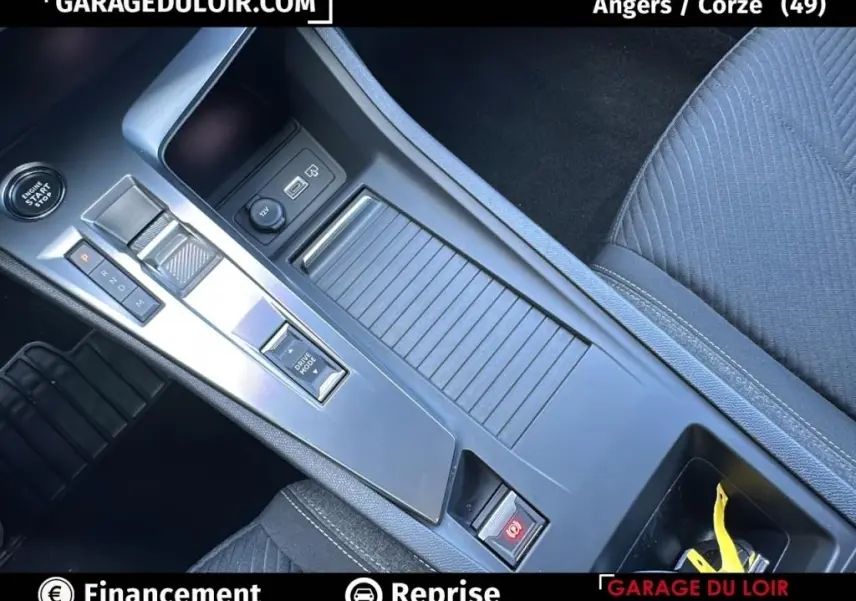 Vue rapprochée de la console centrale grise de la Peugeot 308 2023, avec levier de boîte auto et bouton Drive Mode.