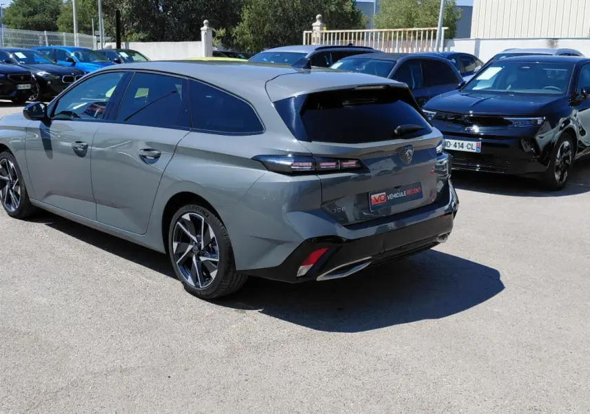 Peugeot 308 SW Hybrid gris vue 3/4 arrière droit, avec jantes alliage 17 pouces et vitres teintées.