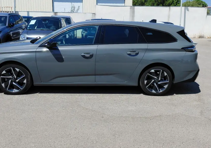 Peugeot 308 SW Hybrid gris vue de profil côté gauche, avec jantes alliage 17 pouces et vitres teintées.
