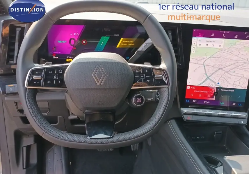 Vue intérieure centrée sur le volant Renault d’un Austral 2025, avec tableau de bord numérique et écran tactile affichant une carte.