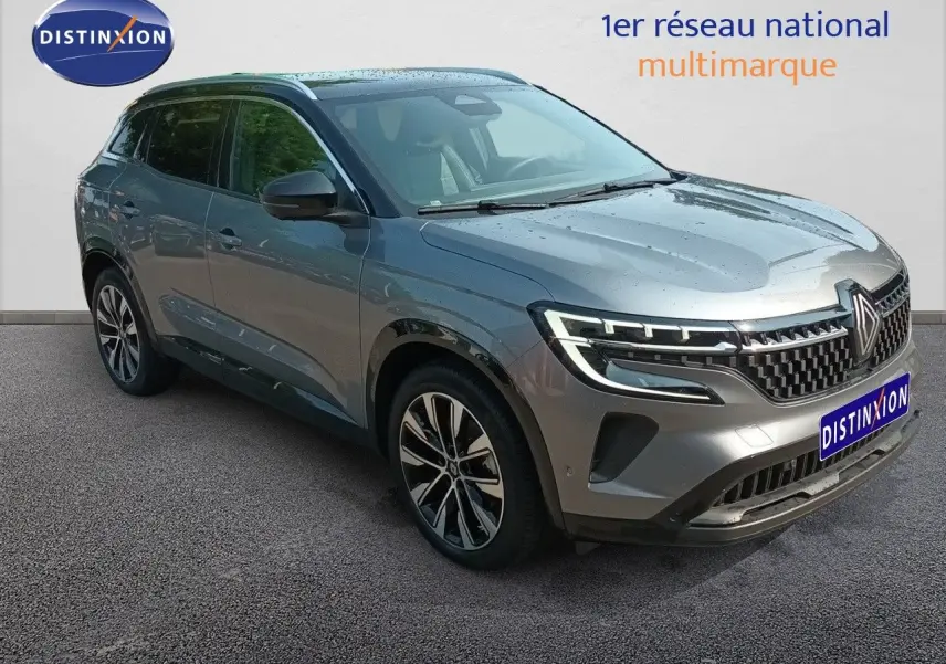 Renault Austral gris schiste métal en 3/4 avant droit, avec calandre distinctive et jantes alliage bicolores.