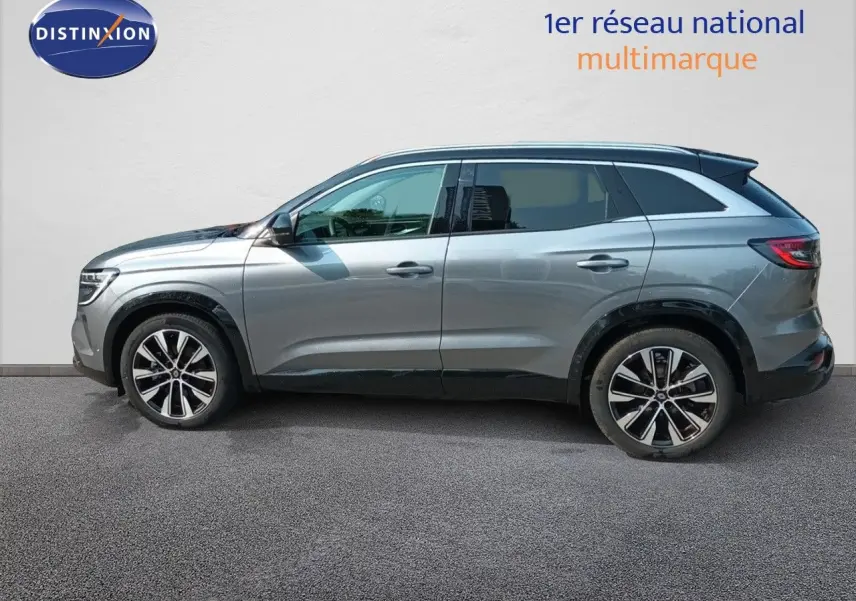 Profil côté gauche d'un Renault Austral 2025 gris schiste métal avec jantes bi-ton et toit noir, sur fond clair neutre.