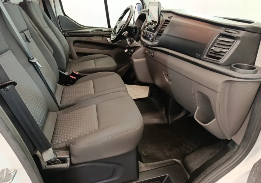 Vue intérieure côté passager du Ford Transit Custom 2020, montrant la banquette trois places et le tableau de bord gris.