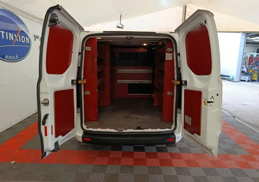 Vue arrière du Ford Transit Custom blanc 2020 avec portes ouvertes et aménagements de rangement rouges dans le coffre.